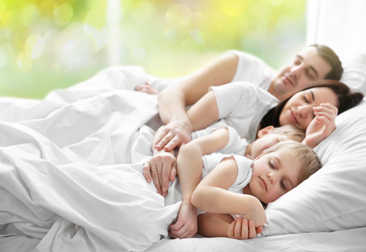 bigstock-Family-sleeping-in-bed-on-abst-130416323.jpg
